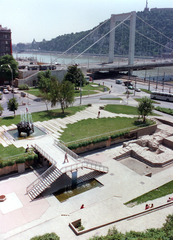 Magyarország, Budapest V., Március 15. tér, park és a római romterület (Contra-aquincum) bemutatóhely az Erzsébet híd pesti hídfője felé nézve. Háttérben a Gellért-hegy., 1975, Hlatky Katalin-Főkert, színes, Budapest, Duna-híd, Sávoly Pál-terv, Fortepan #141323