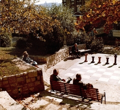 Magyarország, Budapest XI., játszótér a Kelenhegyi útra nézve, szemben a fák takarásában a Gellért Szálló (fürdő bejárat) látszik., 1972, Hlatky Katalin-Főkert, sakk, Budapest, színes, Fortepan #141384