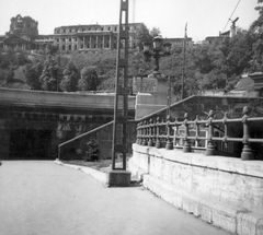 Magyarország, Budapest I., Széchenyi Lánchíd budai hídfője, háttérben a romos Királyi Palota (később Budavári Palota)., 1954, Baráth Endre, lámpa, korlát, villamos, hídfő, épületkár, Turul-szobor, Budapest, Fortepan #14599