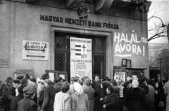 Magyarország, Budapest XI., Móricz Zsigmond körtér - Villányi út sarok., 1956, Klausz Ádám, plakát, forradalom, fodrászat, címer, graffiti, bank, bámészkodás, Kossuth címer, Budapest, Fortepan #146977