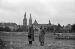 Magyarország, Újszeged, Szeged, Tisza-part, háttérben a Korányi fasor épületei és a Fogadalmi templom., 1955, Fortepan/Album027, templom, Schulek Frigyes-terv, katolikus, neoromán építészet, székesegyház, hátratett kéz, kalap kézben, Fortepan #148964