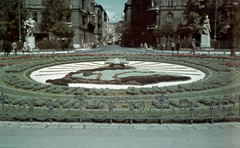 Magyarország, Budapest V., Szabadság tér, irredenta emlékhely virágokból, szemben a Honvéd utca. Az Irredenta szoborcsoportból balra az »Észak« (Kisfaludi Strobl Zsigmond, 1921.), jobbra a »Kelet« (Pásztor János, 1921.)., 1941, Miklós Lajos, színes, szobor, Nagy-Magyarország, irredenta emlékmű, Budapest, virágágyás, Fortepan #153356