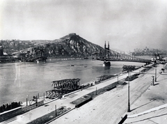 Magyarország, Budapest IX.,Budapest XI., a lerombolt Szabadság (Ferenc József) híd a pesti alsó rakpart felől nézve, háttérben a Gellért-hegy, fenn a Citadella., 1945, Fortepan, háborús kár, Budapest, lámpaoszlop, hídroncs, Fortepan #155561