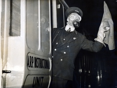 Egyesült Királyság, London, Euston Station, légoltalmi gyakorlat (Air Raid Precautions). A vasúti személyzetei is kioktatják a légoltalmi teendőkre. „ Gázvonatokat" rendeztek be, melynek személyzete gázálarcban és gázvédő öltözetben végzi hivatalos teendőit. A vonat egyik kocsija teljes lég- és gázvédelmi felszerelést tartalmaz s ennek segítségével a személyzet gázsérülteknek elsősegélyt is nyújthat. Egy másik kocsit oktatóhelyiségnek rendeztek be, ahol szemléltető előadásokat tartanak., 1937, Reklámélet folyóirat, gázálarc, Fortepan #156180