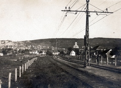 Magyarország, Budaörs, a Budapest-Törökbálint között közlekedő HÉV vonala. A felvétel a város határában, a mai Stefánia utcánál készült. Szemben a Templom téri Nepomuki Szent János-templom., 1917, Szakál Ferenc, HÉV, sínpálya, felsővezeték, Fortepan #156646