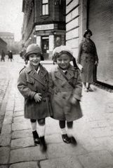 Magyarország, Budapest VII., Bethlen Gábor utca, háttérben a Dembinszky utca sarkán álló ház, távolban a Damjanich utca épületei látszanak., 1931, Kinszki Imre, Budapest, gyerekek, dupla soros kabát, sapka, Fortepan #157067