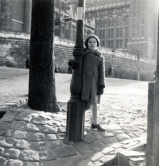 Magyarország, Budapest I., a mai Európa Liget területe, háttérben a Magyar Országos Levéltár., 1938, Boda Balázs, Budapest, kalap, lány, kabát, kesztyű, lámpaoszlop, Fortepan #160431