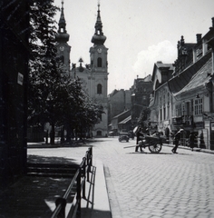 Magyarország, Budapest I., Fő utca a Batthyány tér felé nézve. Szemben a Szent Anna-templom, jobbra az egykori Fehér Kereszt fogadó., 1936, Boda Balázs, Budapest, utcakép, templom, képarány: négyzetes, toronyóra, katolikus, kézikocsi, Fortepan #160462