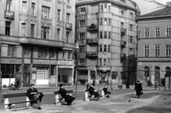 Magyarország, Budapest V., Fővám (Dimitrov) tér, szemben a Váci utca - Só utca sarok., 1954, Gara Andor, Budapest, pad, férfi, üzletportál, olvasás, sarokház, bérház, Fortepan #162699