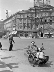 Magyarország, Budapest VI., Oktogon (November 7. tér), Savoy kávéház. Balra az Andrássy (Sztálin) út, szemben a Savoy., 1952, Magyar Rendőr, jármű, utcakép, életkép, neonreklám, kerekesszék, Budapest, Fortepan #16764