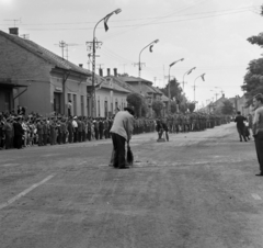 Magyarország, Cegléd, Kossuth tér, országos Dózsa-ünnepség, katonai alakulat felvonulása Dózsa György születésének ötszázadik évfordulója alkalmából. Háttérben a a Kőrösi út házsora., 1972, Péterffy István, felvonulás, Fortepan #170655