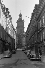 Svédország, Stockholm, a Storkyrkobrinken a Riddarhustorget felől nézve, szemben a Nagytemplom vagy Szent Miklós-templom (Storkyrkan / Sankt Nicolai kyrka)., 1960, Sattler Katalin, toronyóra, Fortepan #171404