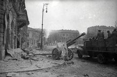 Magyarország, Budapest VIII., Kálvária tér, a Losonci utca torkolatától a Baross utca sarkán álló kétszintes ház felé nézve., 1945, Vörös Hadsereg, teherautó, szovjet katona, Budapest, páncéltörő ágyú, 10.5 cm leFH 18 tarack, Fortepan #175135