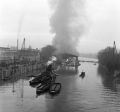 Magyarország, Óbuda, Budapest III., Óbudai Hajógyár, a Hajógyári-öböl az Árpád hídról nézve. A hajóvédő csarnokban egy átadás előtt álló gőzhajón a keletkezett tüzet oltják. Újjáépítés után ez lett a SZOT Budapest üdülőhajó., 1959, Bojár Sándor, Budapest, Fortepan #178884