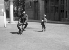 Magyarország, Budapest II., a Hunnia Filmgyár pasaréti telepének udvara, a műtermek előtt., 1952, Bojár Sándor, Budapest, tréfálkozás, kisfiú, kerékpár, mutatvány, Fortepan #179638