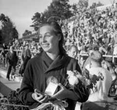 Finnország, Helsinki, XV. nyári olimpiai játékok. Szőke Kató kétszeres olimpiai bajnok úszónő., 1952, Bojár Sándor, képarány: négyzetes, mosoly, kézben tartani, érem, virágcsokor, közönség, híres ember, olimpiai bajnok, Fortepan #180428