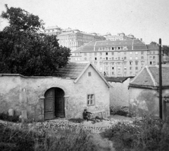 Magyarország, Tabán, Budapest I., kilátás a Harkály utcától, élőtérben a Holdvilág utca, háttérben a Bethlen-udvar és a Királyi Palota (később Budavári Palota)., 1930, Jankovszky György, kapu, férfi, ül, Budapest, Fortepan #18411