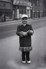 Magyarország, Budapest V., Szervita (Martinelli) tér, a háttérben középen a 3. számú ház., 1954, Ferencz Zoltán Zénó, Budapest, kisfiú, üzletportál, sapka, télikabát, Fortepan #184135