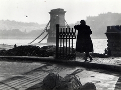 Magyarország, Budapest I., a lerombolt Széchenyi Lánchíd és a Királyi Palota (később Budavári Palota) a Széchenyi István (Ferenc József) tér felől nézve., 1945, Fortepan, híd, Budapest, kabát, hídroncs, vasbeton, nő, Fortepan #186685