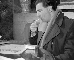 Magyarország, Budapest, Miloš Schmidberger, a barandovi filmstúdió helyettes igazgatója., 1960, Kotnyek Antal, portré, divat, cigaretta, dohányzás, bútor, újság, enteriőr, férfi, öngyújtó, Népsport, rágyújt, Fortepan #18708