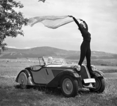 Hungary, Solymár, BMW 319 Roadster személygépkocsi. Háttérben a Kevély-hegycsoport egy része (a Nagy-Kevély és az Ezüst-Kevély)., 1936, Szöllősy Kálmán, Gerrman brand, BMW-brand, posture, gesture, automobile, wind, convertible, spreading, girls'n'cars, standing on a car, Fortepan #18780