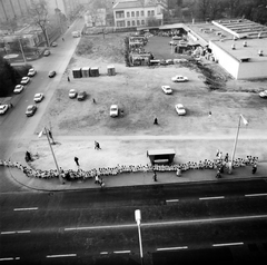 Magyarország, Budapest XVII., kilátás a Ferihegyi út 78. számú házból, Fő tér (Rákoskeresztúr városközpont), balra az Egészségház utca. Kisiskolások lánca a Ferihegyi úti Általános Iskolától a Kaszáló utcai Szívesházig. Dohányzás elleni felhívást adtak kézről kézre a gyerekek, amit Dr. Csehák Juditnak a minisztertanács-elnökhelyettesének adtak át., 1986, Szalay Béla, Budapest, Fortepan #187918