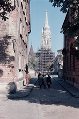 Magyarország, budai Vár, Budapest I., Tóth Árpád sétány, szemben a Szentháromság utca és a Mátyás-templom., 1955, Lőrincze Judit, Budapest, utcakép, színes, állvány, Fortepan #188677