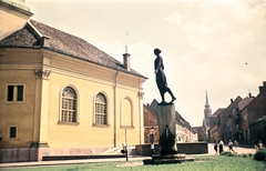 Hungary, Budapest I., Bécsi kapu tér, Kazinczy-emlékkút (Pásztor János, 1936.). Balra a Budavári Evangélikus templom, jobbra a Fortuna utca és a Mátyás-templom., 1965, Wittner Lucia, Budapest, sculpture, Fortepan #190145