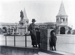 Hungary, Budapest I., Szentháromság tér, háttérben Szent István szobra (Stróbl Alajos, 1906.) a Halászbástyánál., 1917, Zagyva Tiborné, Budapest, hands in pockets, hat, family, monument, horse sculpture, Fortepan #190225