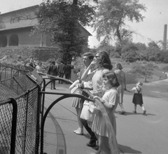 Magyarország, Városliget,Állatkert, Budapest XIV., Gábor Miklós, Ruttkai Éva és leányuk, Júlia., 1961, Kotnyek Antal, híres ember, divat, család, cipő, mosoly, fa, napszemüveg, gyerekek, épületdísz, kerítés, hajviselet, táska, színész, állatkert, tábla, Budapest, Fortepan #19127