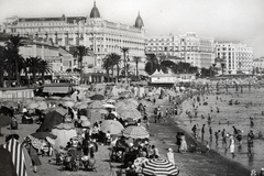 Franciaország, Cannes, tengerpart, strand. Balra fent a Croisette körút (Boulevard de la Croisette), a kupolás épület a Carlton Hotel., 1933, Kieselbach Gyula, napernyő, Fortepan #191723