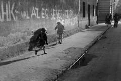 Magyarország, Budapest VIII., Kis Stáció utca a Harminckettesek tere felé nézve, a kép jobb felső sarkában a Kisfaludy utca torkolata látszik., 1954, Kriss Géza, Budapest, Best of, gyerekek, jelmondat, árnyék, roller, falfirka, járda, MHK Mozgalom, Fortepan #191784