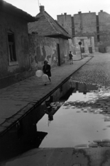 Hungary, Budapest VIII., a mára megszűnt Beniczky Lajos utca a Bókay János utca felé nézve., 1954, Kriss Géza, Budapest, girl, reflection, firewall, pavement, puddle, baloon, Fortepan #191795