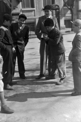 Hungary, Budapest VIII., Horváth Mihály tér, snúrozó fiúk. Háttérben a Horváth Mihály téri Gyakorló Általános Iskola (később Budapesti Fazekas Mihály Gyakorló Általános Iskola és Gimnázium)., 1955, Kriss Géza, Budapest, hands in pockets, suit, toy, boys, Fortepan #191882