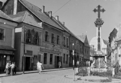 Magyarország, Szentendre, Fő (Marx) tér a Rákóczi Ferenc utca és a Városháza épülete felé nézve, előtérben a Szerb (kalmár) kereszt., 1954, Keveházi János, utcakép, szálloda, felirat, kereszt_jelkép, tér, Fortepan #197070