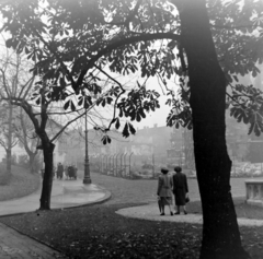 Magyarország, budai Vár, Budapest I., Szentháromság tér, szemben a Tárnok utca - Szentháromság utca sarkán a régi budai Városháza épülete. Jobbra a Mátyás-templom., 1955, Keveházi János, Budapest, képarány: négyzetes, kosztüm, drótkerítés, séta, Fortepan #197302