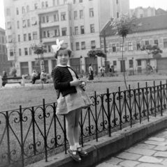 Magyarország, Budapest VIII., Kálvária tér, háttérben a Karácsony Sándor utca - Baross utca sarkán álló ház.
, 1955, Keveházi János, Budapest, kislány, képarány: négyzetes, korlát, masni, kardigán, Fortepan #197318