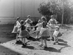 Hungary, Buják, a felvétel a Tours-i Szent Márton-templom mellett készült., 1957, Keveházi János, kids, folk costume, round dance, Fortepan #197552