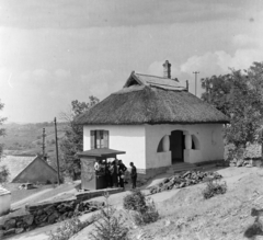 Magyarország,Balaton, Tihany, a felvétel a mai Borsos Miklós tér és a Bencés Apátság közötti területen készült., 1959, Keveházi János, kosár, nádtető, népi építészet, trafik, szalmakalap, Fortepan #197734