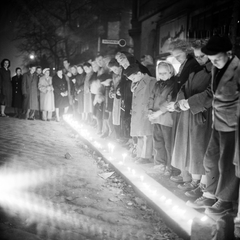 Magyarország, Budapest, megemlékezés halottak napján egy buszmegállóban, az 1956-os forradalom alatt elkövetett egyik atrocitás helyszínén., 1956, ETH Zürich, Comet Photo AG/Jack Metzger, tömeg, gyertya, megemlékezés, éjszaka, gyász, kabát, gyertyafény, képarány: négyzetes, Fortepan #197808