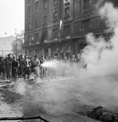 Magyarország, Budapest V., Kossuth Lajos utca, a könyvégetés maradványait oltják a Magyar Szovjet Társaság Országos Központja előtt, háttérben az Astoria szálló., 1956, ETH Zürich, Comet Photo AG/Jack Metzger, Budapest, zászló, képarány: négyzetes, bámészkodás, füst, Fortepan #197820