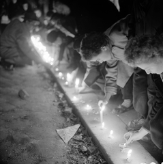 Magyarország, Budapest, megemlékezés halottak napján egy buszmegállóban, az 1956-os forradalom alatt elkövetett egyik atrocitás helyszínén., 1956, ETH Zürich, Comet Photo AG/Jack Metzger, tömeg, forradalom, gyertya, megemlékezés, éjszaka, gyász, kabát, gyertyafény, képarány: négyzetes, Fortepan #197833