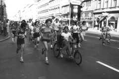 Magyarország, Budapest VII.,Budapest VIII., Rákóczi út az Osvát utca torkolatától a Keleti pályaudvar felé nézve. A Sport Aid elnevezésű, az afrikai éhezők megsegítésére rendezett futóverseny., 1986, Szalay Zoltán, kerekesszék, mozgássérült, Budapest, Fortepan #198254