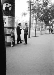 Magyarország, Budapest V., seftelő (engedély nélküli üzletelő) igazoltatása a Károly (Tanács) körút 24., a Bizományi Áruház Vállalat Műszaki Boltja előtt. Háttérben balra a Dohány utca., 1965, Szalay Zoltán, Budapest, hirdetőoszlop, rendőr, igazoltatás, Fortepan #198597