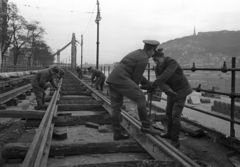 Magyarország, Budapest V., Dunakorzó, a villamospálya javítása. Háttérben a lerombolt Erzsébet híd pesti hídfője és a Gellért-hegy., 1956, Bauer Sándor, Budapest, sínpálya, talpfa, Fortepan #199450