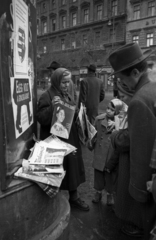 Magyarország, Budapest VI., Andrássy út (Magyar Ifjúság útja), a háttérben középen a 28-as számú ház, újságárus a Nagymező utca sarkán., 1956, Bauer Sándor, Budapest, plakát, kíváncsiság, újság, Kossuth címer, francia felirat, Fortepan #199477