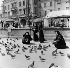 Olaszország, Padova, a Piazza del Santo a Szent Antal-bazilika előtt. Háttérben a 14-es számú ház, ennek bal sarkánál a Via Beato Luca Belludi nyílik., 1970, Faragó László, galamb, apáca, madáretetés, Fortepan #202354