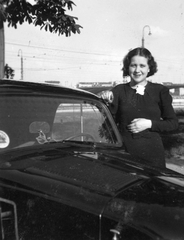 Magyarország, Budapest II., Árpád fejedelem útja a Lukács fürdő előtt, háttérben a Margit híd., 1939, Fortepan, portré, nő, automobil, Budapest, lányok-járművek, Fortepan #20540