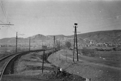 Magyarország, Budaörs, a Budapest-Törökbálint között közlekedő HÉV vonala a Kinizsi utcai átjárónál, szemben a Templom téri Nepomuki Szent János-templom., 1960, Belházy Miklós, villanyoszlop, sínpálya, Fortepan #210001