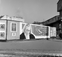 Magyarország, Budapest II., Margit körút (Mártírok útja), előtérben a Retek utca és a Lövőház utca közötti metróépítési terület kerítése. A Fővárosi Moziüzemi Vállalat (FŐMO) által forgalmazott film plakátja. Háttérben középen a Margit körúti egykori fogház épülete, jobbra a Lövőház utca sarkán a metróépítés felvonótornya., 1970, FŐFOTÓ, Budapest, Fortepan #214295